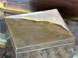 a small box sitting on a glass table next to a chest of drawers