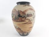 a vase with a painting on it sitting on a table