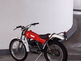 a red motorcycle parked in a parking garage next to a white wall