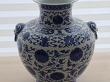 a blue and white vase sitting on a wooden table
