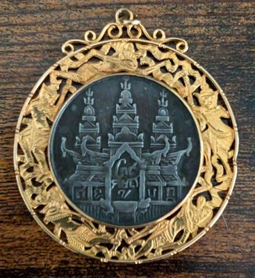 une image représentant un médaillon doré et noir orné d'un château
