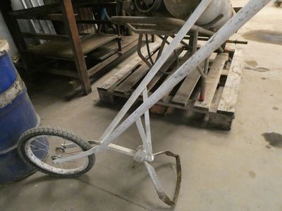 un petit diable avec une roue au milieu d'un garage