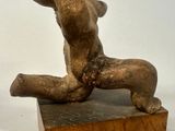 a statue of a nude woman sitting on a block