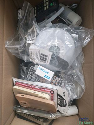 a cardboard box filled with electronic devices and other items