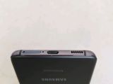 the back of a black samsung phone sitting on top of a table