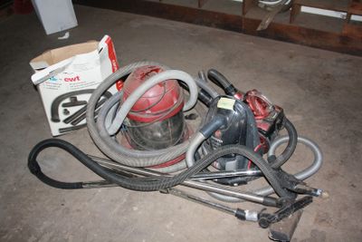 a pile of vacuum cleaners and other tools on the floor