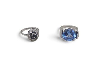 a pair of rings with a blue topaz stone and black diamonds