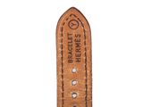 the brown leather watch strap has white stitching on it