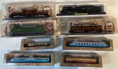 six modèles réduits de trains différents, dans des sachets en plastique, posés sur une table