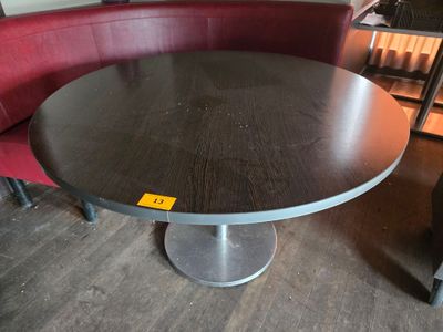 une table ronde avec un piètement en métal dans une pièce