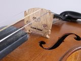 a close up of a violin with a bow on the back of it