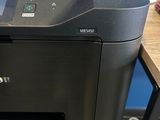 a printer that is sitting on a desk next to a cell phone