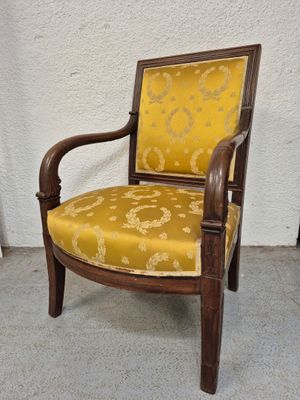 une vieille chaise dont l'assise est recouverte d'un tissu jaune