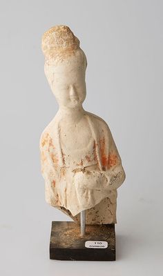 une image représentant une statue d'une femme assise sur un socle en bois