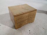 une petite boîte en bois posée sur une surface blanche