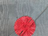 a close up of a piece of fabric with a red flower on it