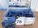 une ponceuse électrique et une boîte à outils posées sur une table en bois
