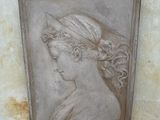 an old picture of a woman ' s head hanging on a wall
