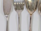 several spoons, forks and spoons are lined up on a white surface