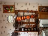 une petite cuisine équipée d'une cuisinière, d'un micro-ondes et de casseroles et poêles accrochées au mur