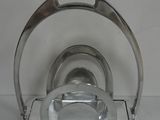 a silver plate and a silver plate holder on a white table