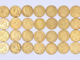 a close up of a pile of gold coins on a white surface