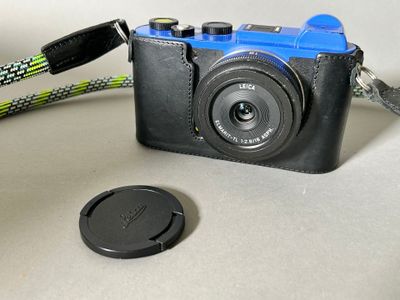 a black camera with a blue camera strap and a black camera