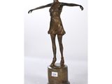 une statue en bronze représentant une femme tenant une raquette de tennis