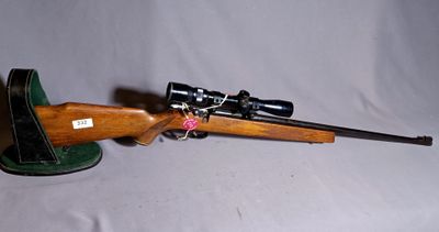 a close up of a rifle with a hat on a table