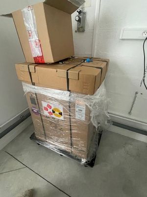 une pile de cartons posée sur un chariot dans une pièce