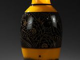 un vase noir et jaune posé sur une table