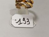 gros plan d'une bague sur une surface blanche avec une étiquette de prix