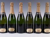 six bottles of champagne are lined up in a row