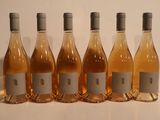 six bottles of wine are lined up in a row on a table