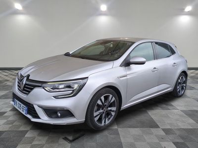 une voiture argentée garée dans une pièce au sol en damier