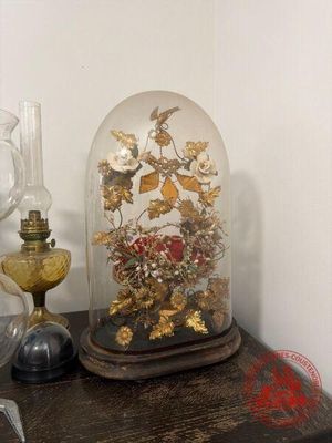 une clochette posée sur une table, dans laquelle se trouve un bouquet de fleurs