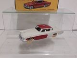 a red and white toy car on display in a glass case