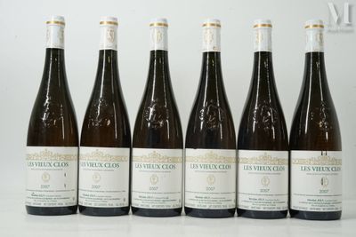 six bouteilles de vin sont alignées sur une table