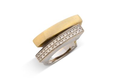 un gros plan d'une bague sertie de diamants sur une surface blanche