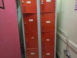 deux casiers dans le couloir d'un immeuble dont la porte est rose