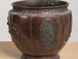 a brown vase sitting on top of a wooden table