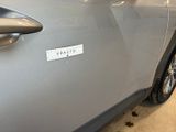 a silver car with a sticker on the side of it