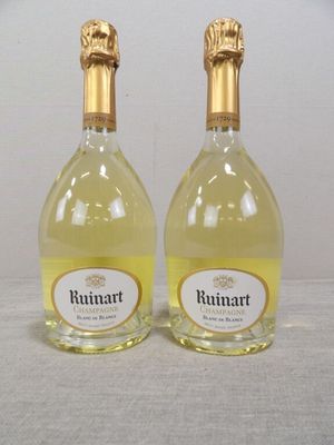 deux bouteilles de vin posées sur une table l'une à côté de l'autre
