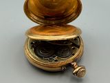 a gold pocket watch sitting on top of a table