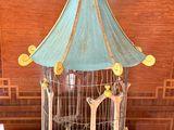 a bird cage with a bird inside of it on a table