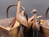 these are two wooden birds sitting in a basket on a table