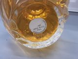 a glass vase with a label on it sitting on a table