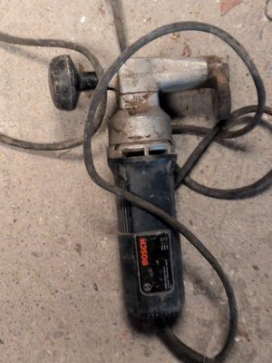 a drill that is laying on the ground next to a piece of metal
