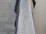 a wedding dress hanging on a clothes rack in a room