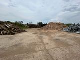 un tas de bois posé au milieu d'un champ de terre battue